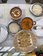 Mesa posta com caris, arroz basmati e pão indiano no Restaurant Odaan